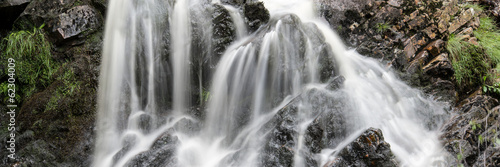 Panorama landscape waterfall detail flowing over rocks in Summer