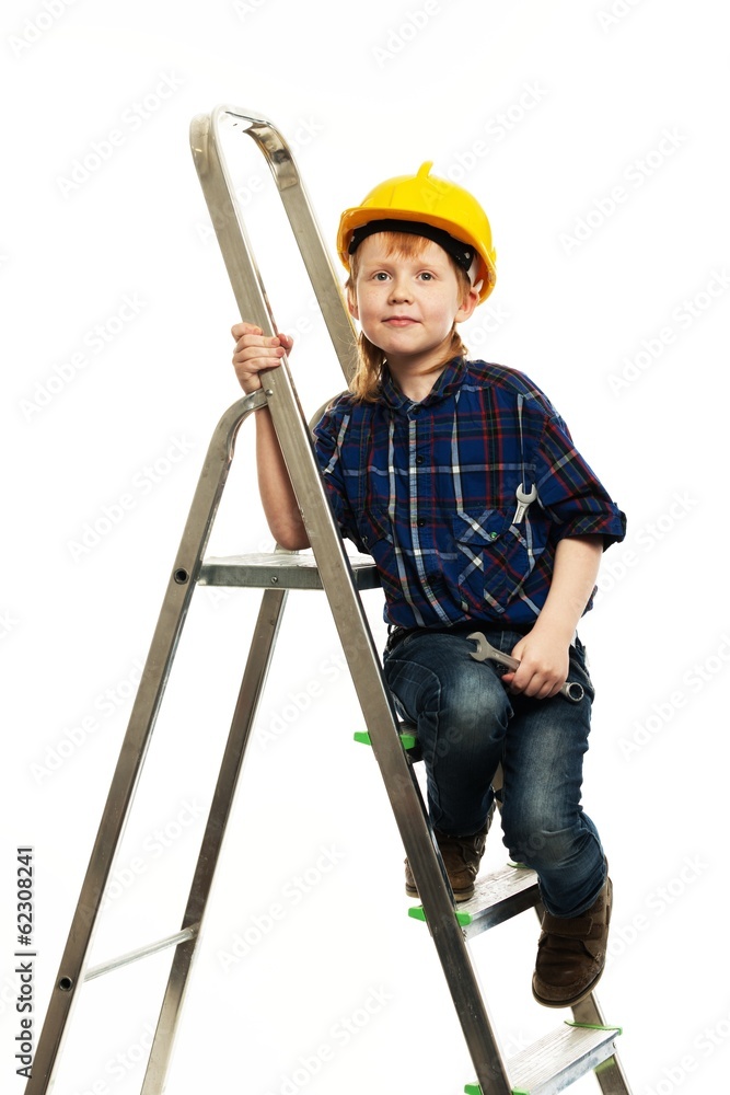 Little boy in protective helmet with wrench tool on a ladder Little boy in protective helmet with wrench tool on a ladder