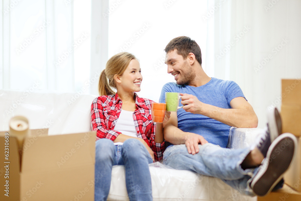 smiling couple relaxing on sofa in new home smiling couple relaxing on sofa in new home