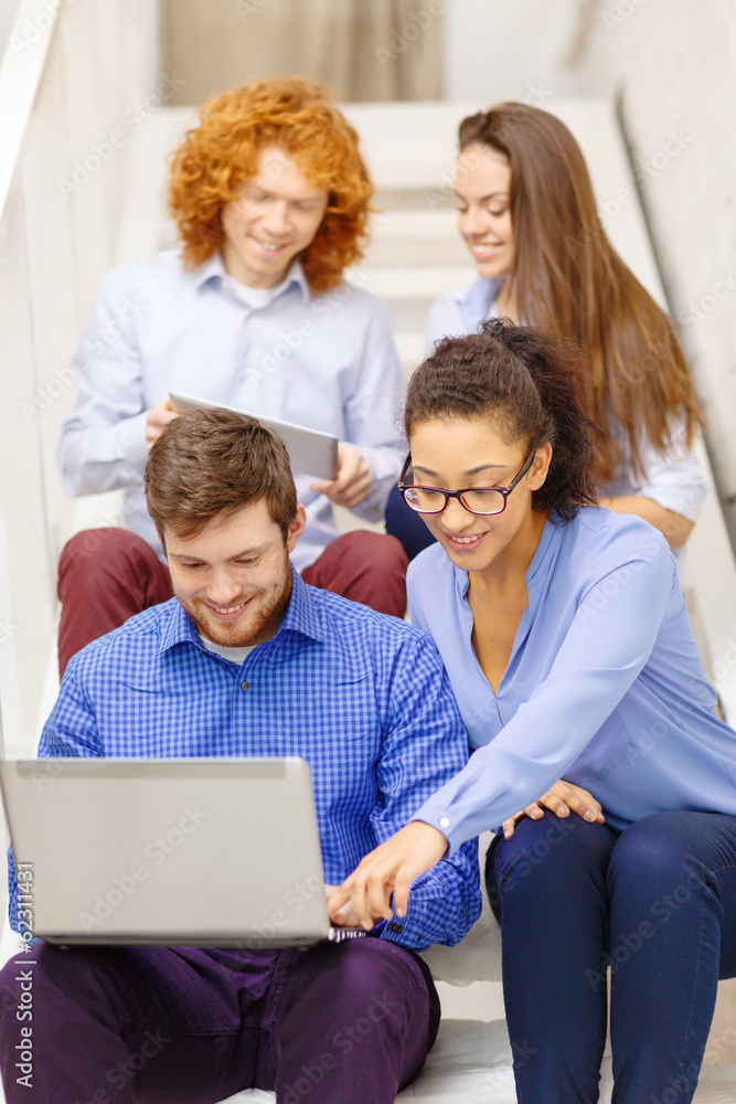 team with laptop and tablet pc on staircase team with laptop and tablet pc on staircase