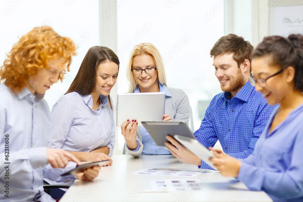 smiling team with table pc and papers working