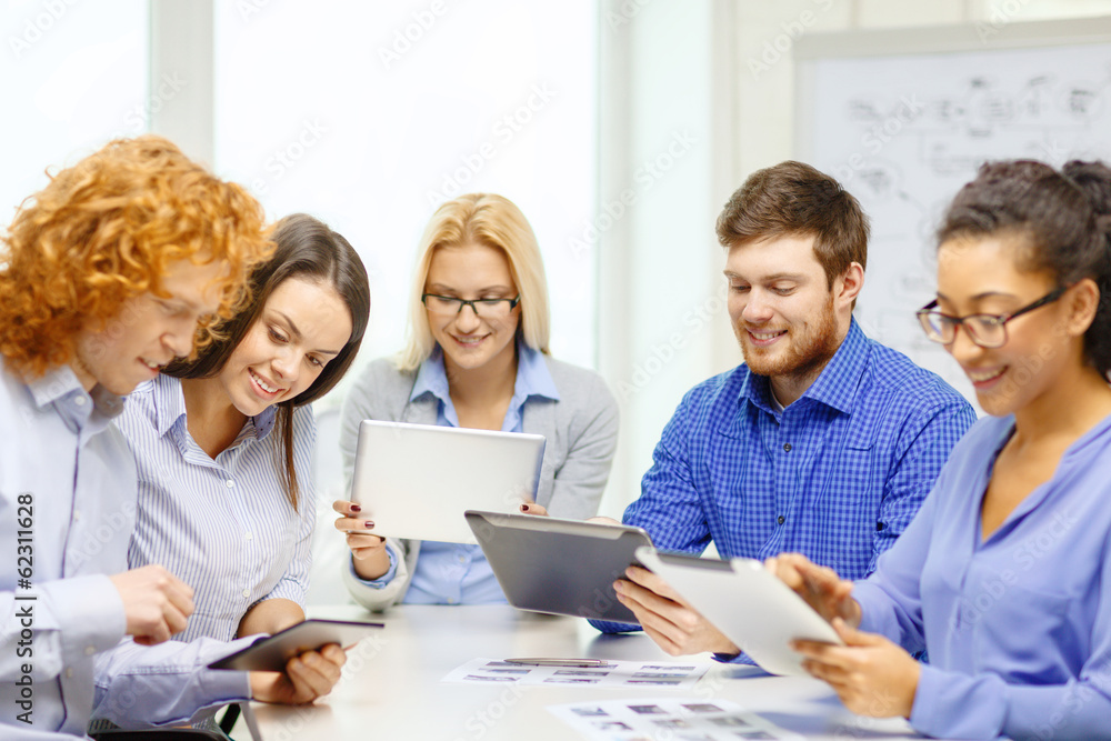 smiling team with table pc and papers working