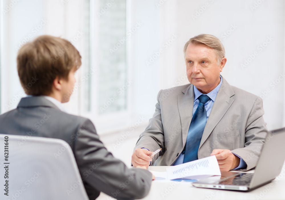 older man and young man having meeting in office older man and young man having meeting in office