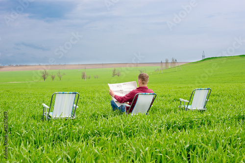 man reading a newspaper outdoors