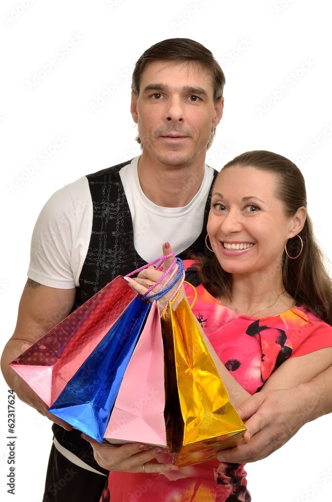 Happy smiling couple husband and wife with gift bags in hands Happy smiling couple husband and wife with gift bags in hands