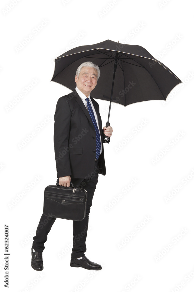.Senior businessman with briefcase and umbrella. .Senior businessman with briefcase and umbrella.