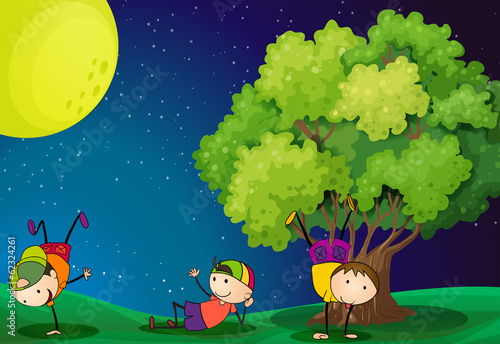 Three kids playing near the tree under the fullmoon