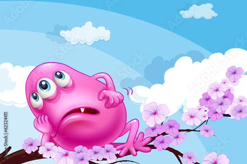 A pink monster resting at a branch of a tree