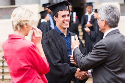 male graduate handshaking with his grandfather