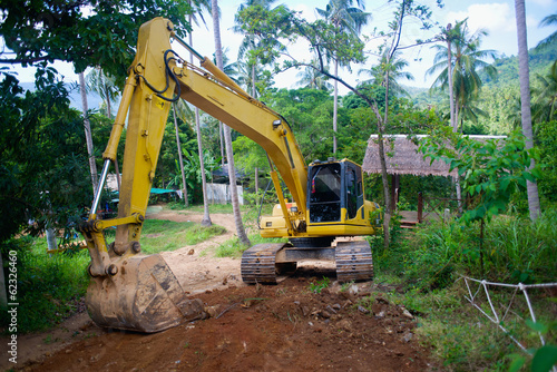 yellow loader mashine digging the road