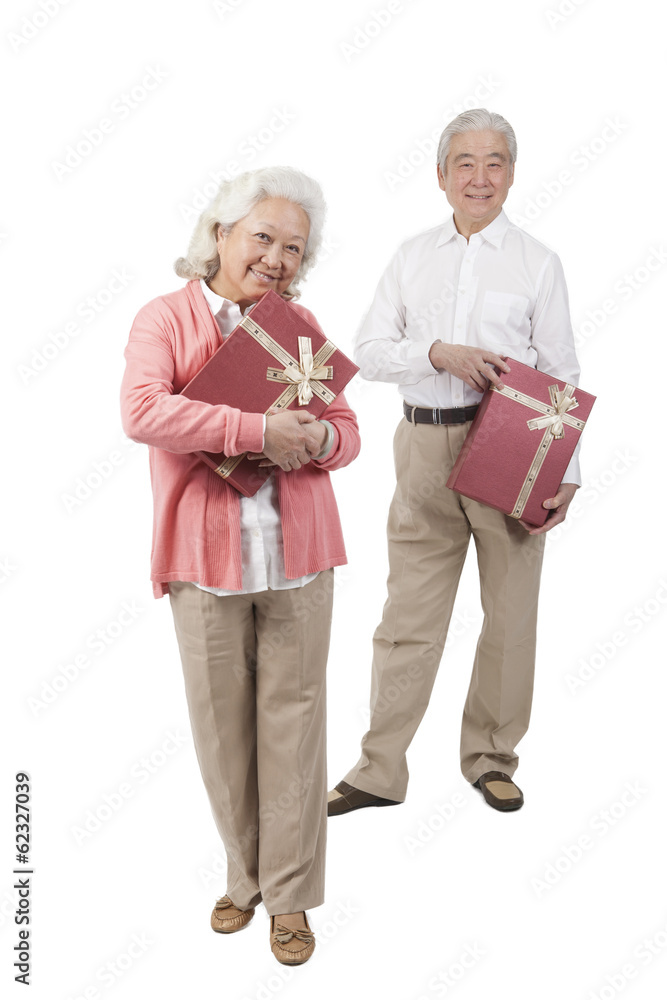 .Senior couple holding gift box. .Senior couple holding gift box.