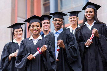 young graduates standing in front of university building