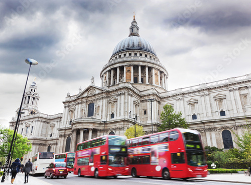 St Paul's Cathedral in London, the UK. Red buses, cloudy sky