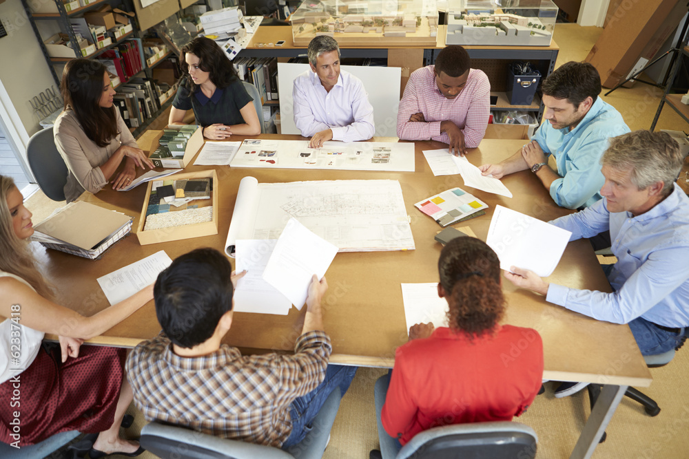 Group Of Architects Sitting Around Table Having Meeting