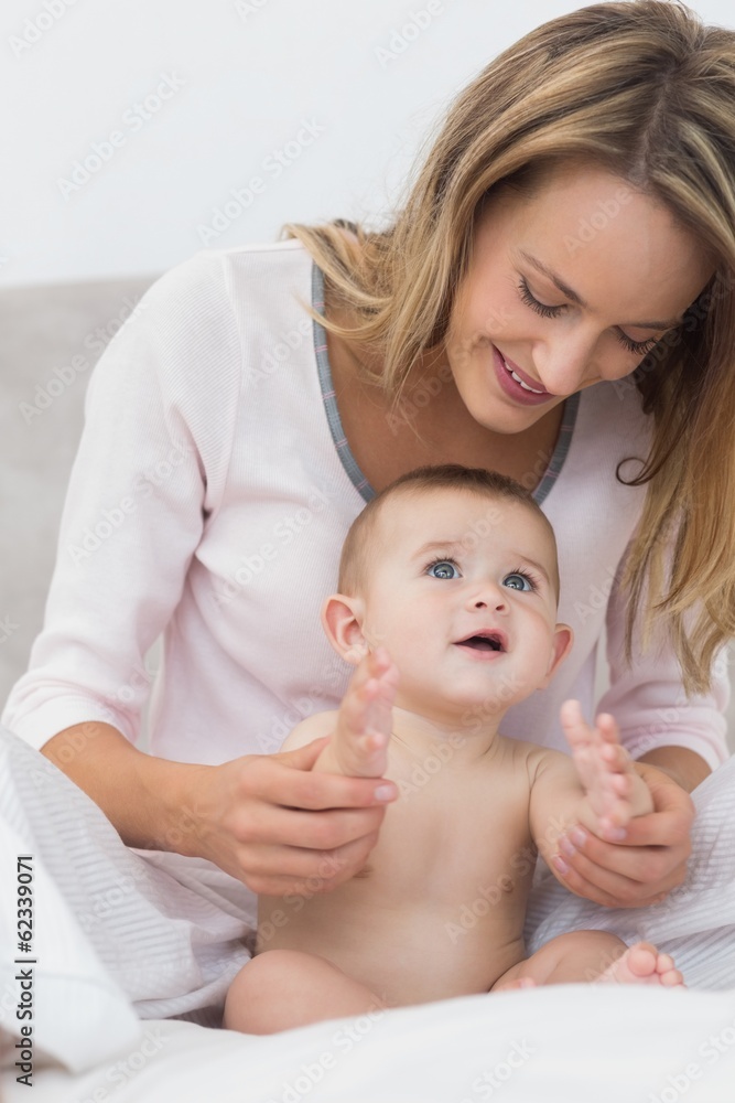 Smiling mother playing with baby boy Smiling mother playing with baby boy