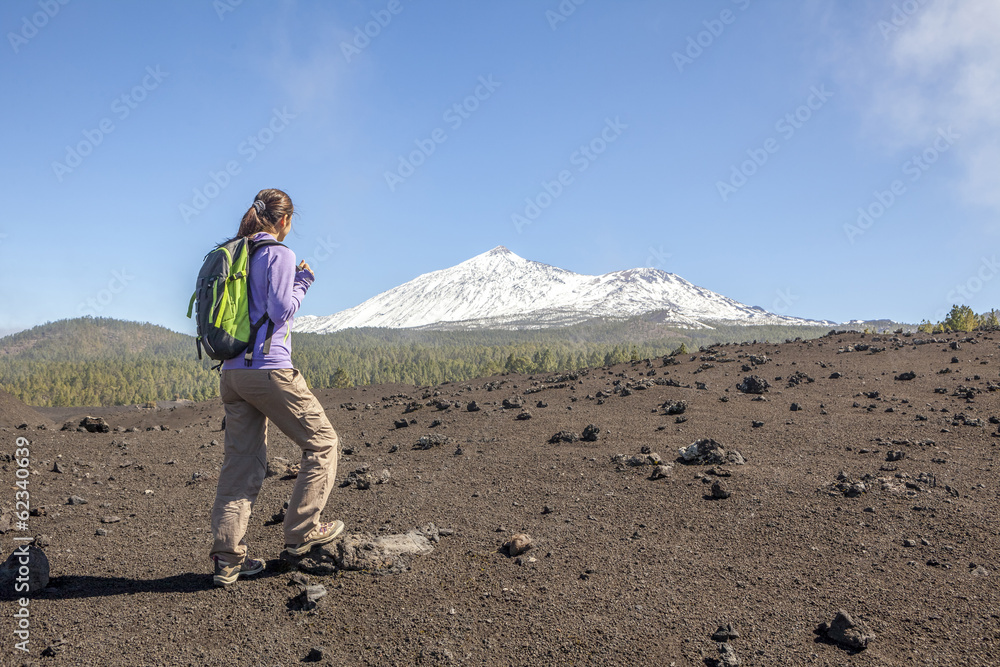 young woman on top of a mountain enjoying the view of volcano te