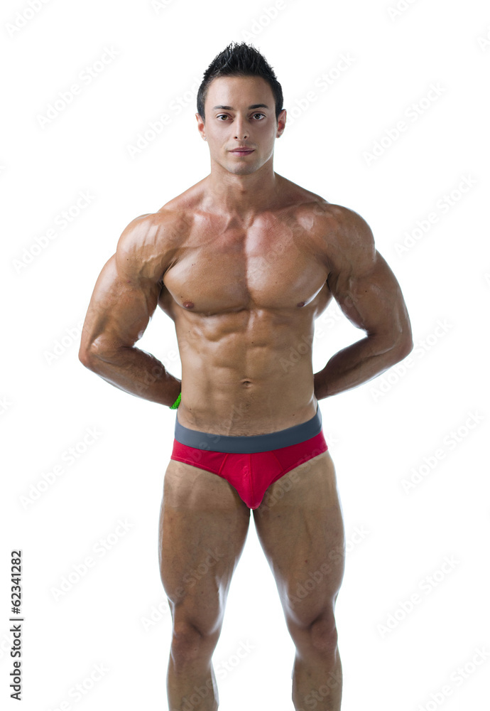 Young muscular bodybuilder standing, hands behind his back Young muscular bodybuilder standing, hands behind his back