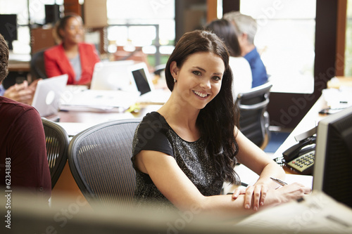 Businesswoman Working At Desk With Meeting In Background Free Download Businesswoman Working At Desk With Meeting In Background - GFXLoad