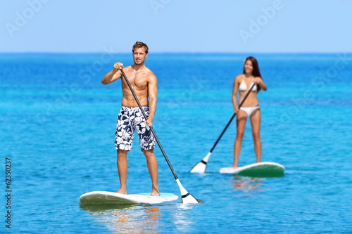 Foto Paddleboard beach people on stand up paddle board
