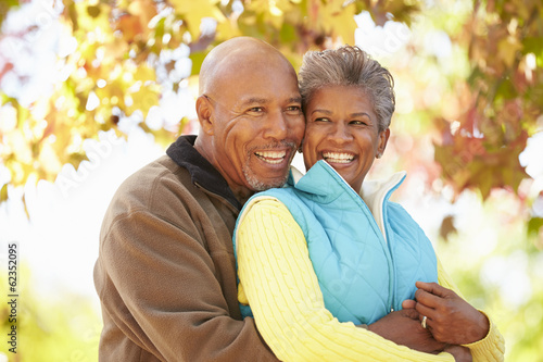 Senior Couple Walking Through Autumn Woodland