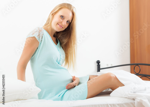  pregnancy woman in nightdress on bed