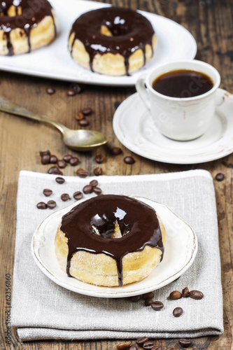 Delicious donut with chocolate on wooden table