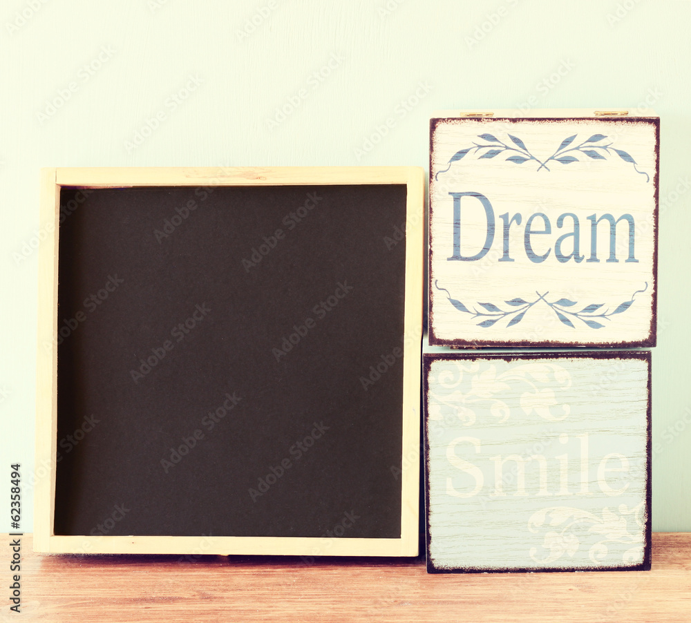 Fototapeta premium blackboard and wooden boxes over wooden table 