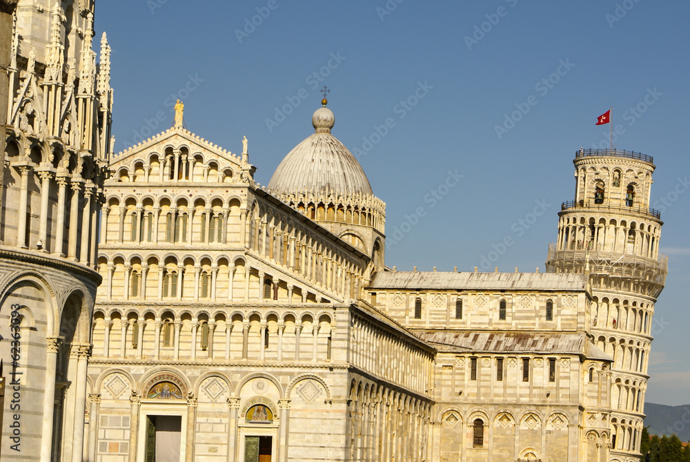 Pisa Cathedral Square with green grass on a meadow and clear blu