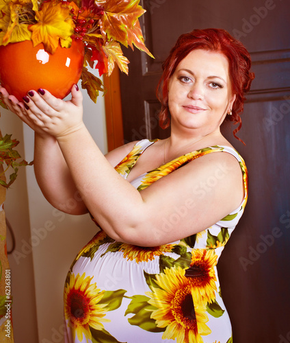 reg haired pregnant plus size woman and orange flowerpot