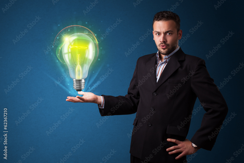 Glowing lightbulb in the hand of a businessman Glowing lightbulb in the hand of a businessman