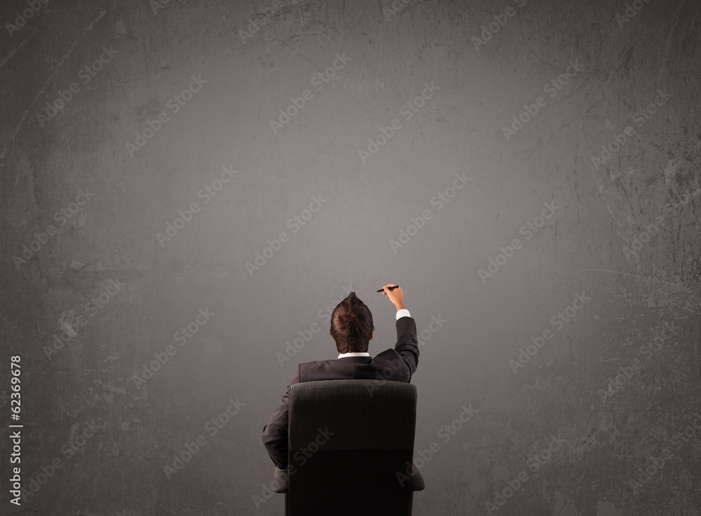 Businessman sitting in front of a wall with copy space Businessman sitting in front of a wall with copy space