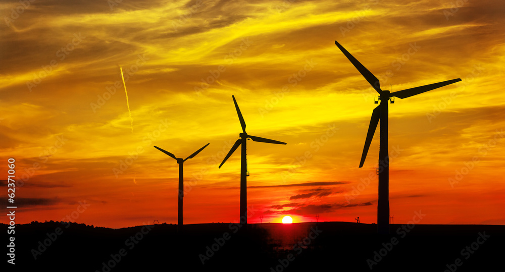 Obraz premium Silhouette of wind power station at sunset.