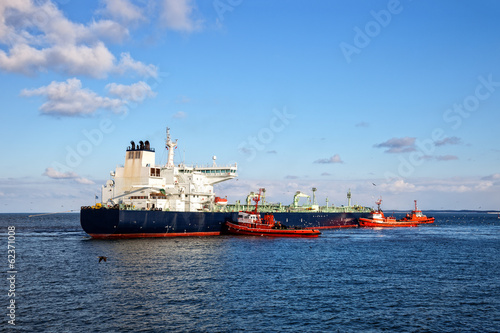 A huge oil tanker and three tugboats at work. © Nightman1965