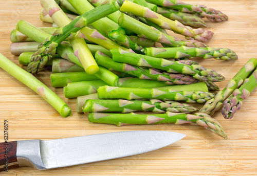 Cut asparagus on cutting board with knife
