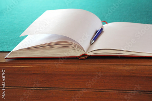 Photos Open guestbook on the table with green cloth