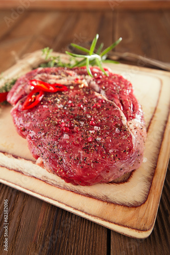 raw Beef steak on a wooden board and table