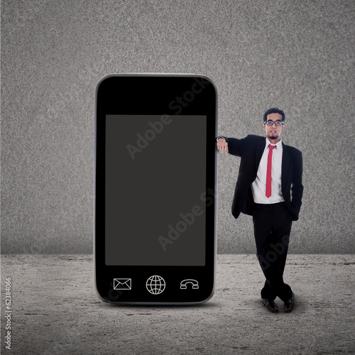 Businessman and smartphone on grey