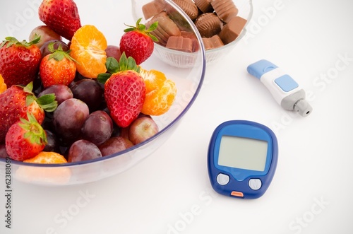 Glucose meter device with accessories. Fruits and chocolates