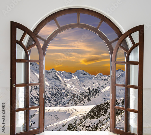 Obraz Drzwi łukowe otworzyły się z widokiem na szczyty zaśnieżonych gór i