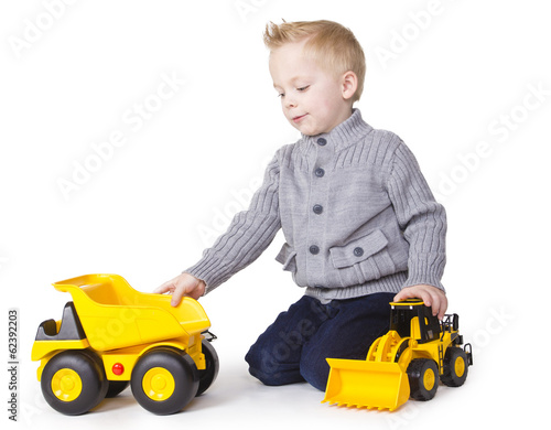 Cute Boy playing with toy trucks