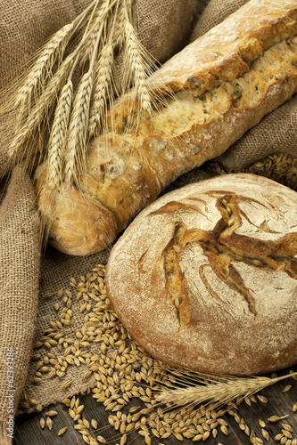 Fresh bread and rye on the wooden board photo