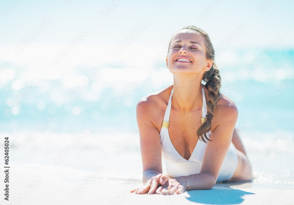 Obraz premium Relaxed young woman laying at seaside