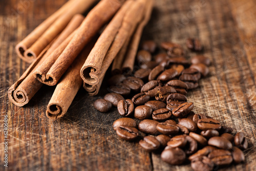 Coffee and cinnamon sticks on grunge wooden background macro