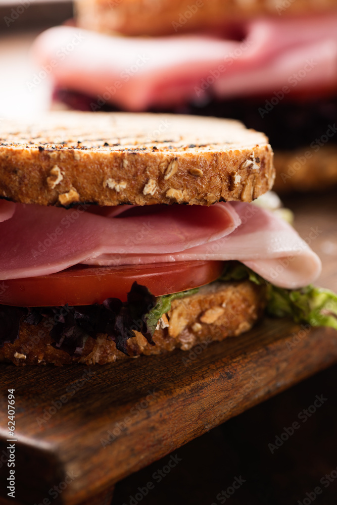 Sandwich with ham salad tomato on cutting board close up