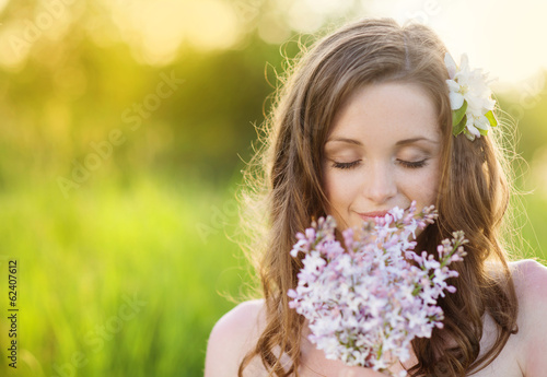 Beautiful spring girl with flowers on the meadow