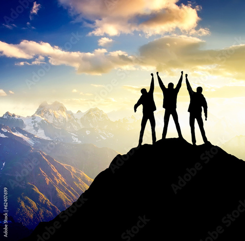 Silhouette of team on mountain peak. Active life concept