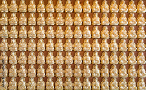 Thousand golden buddha sculpture on a wall