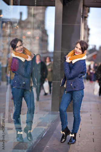 Pretty young girl standing at shopfront