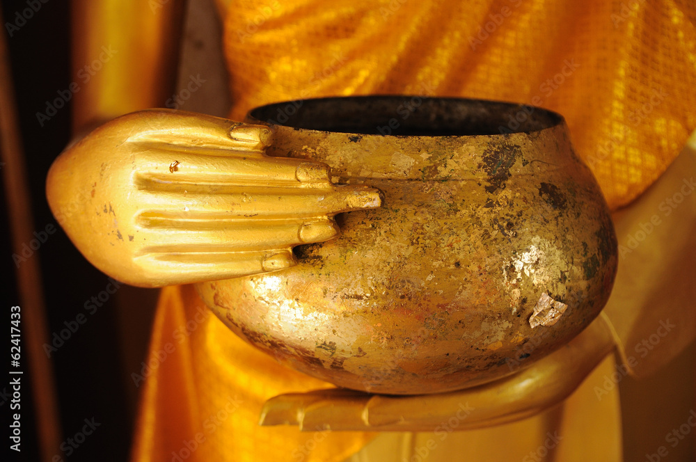 Close up hand of  statue Buddha holding monk  alms-bowl