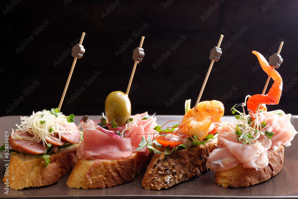 Tapas on Crusty Bread - Selection of Spanish tapas served Stock Photo |  Adobe Stock